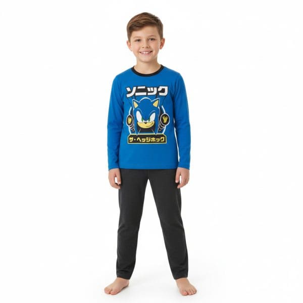 Niño con pijama azul y pantalones oscuros, sonriendo, en fondo blanco.