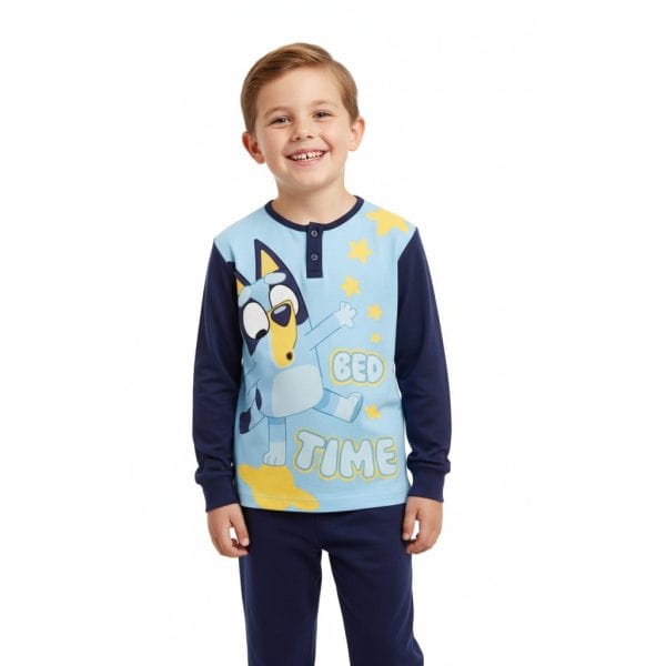 Niño con pijama de dibujos de unicornio y estrellas en tonos azules y amarillos.