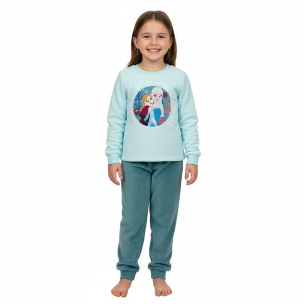 Niña sonriendo con pijama de Frozen en fondo blanco.