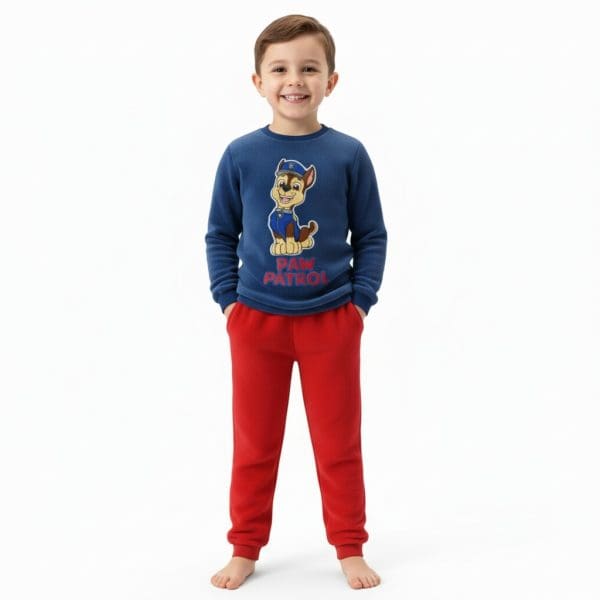 Niño con pijama de Paw Patrol y pantalones rojos, sonriendo.