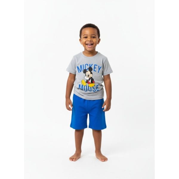Niño feliz con camiseta de Mickey Mouse y pantalones cortos azules.