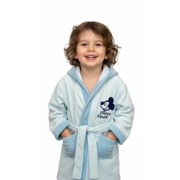 Niña con bata de Mickey Mouse en color azul y blanco, sonriendo felizmente.