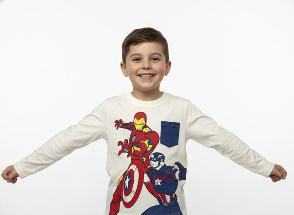 Niño con camiseta de superhéroes de Marvel en fondo blanco.