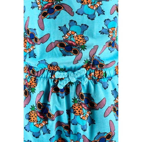 Ropa de verano con estampado de piñas y gafas de sol en fondo azul.